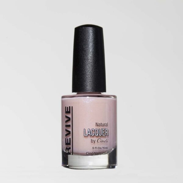 A Bottle Of Revive Natural Lacquer By Cindi, In A Pale Pink Shade, Against A White Background.